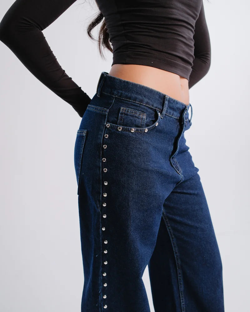 Metal stud details at the pockets and side of dark-blue jeans